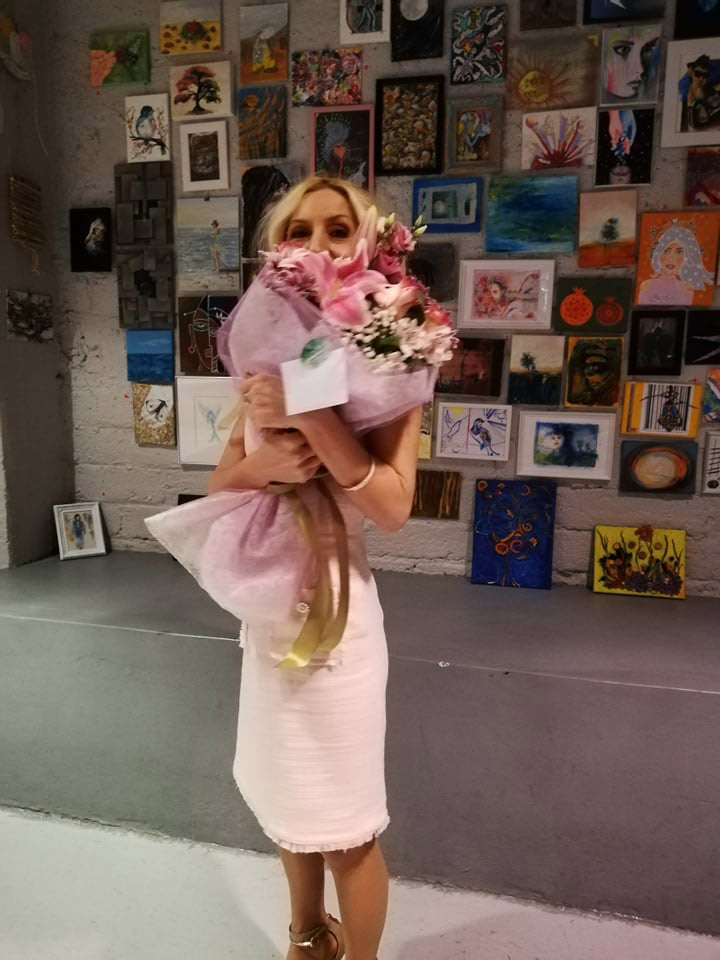 Alexandra Kollaros with flowers at Earth K44 SURPRISE 9 exhibition