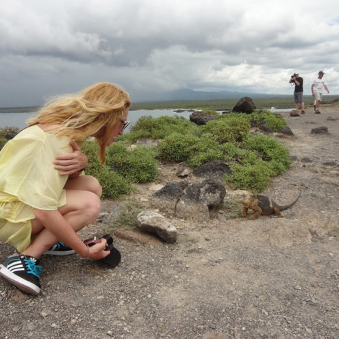 Alexandra Kollaros approaching an iguana at galapagos