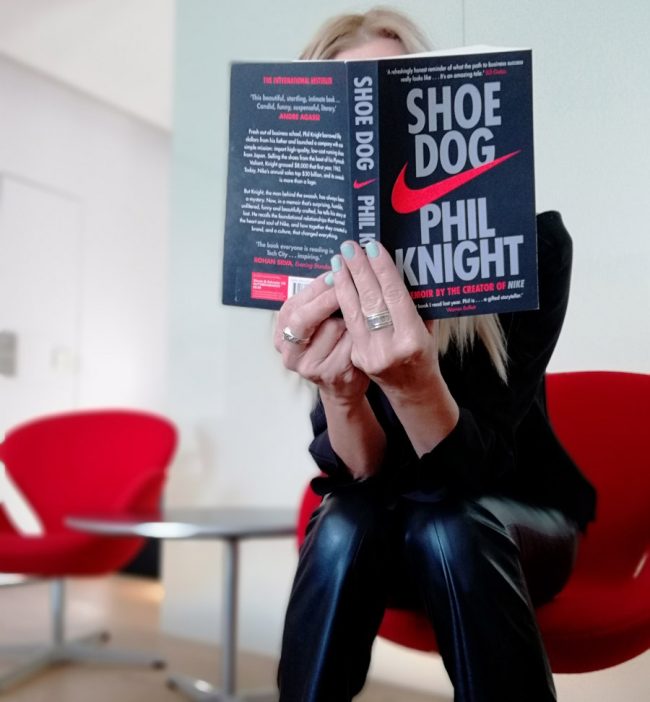 Alexandra Kollaros reading Shoe Dog book