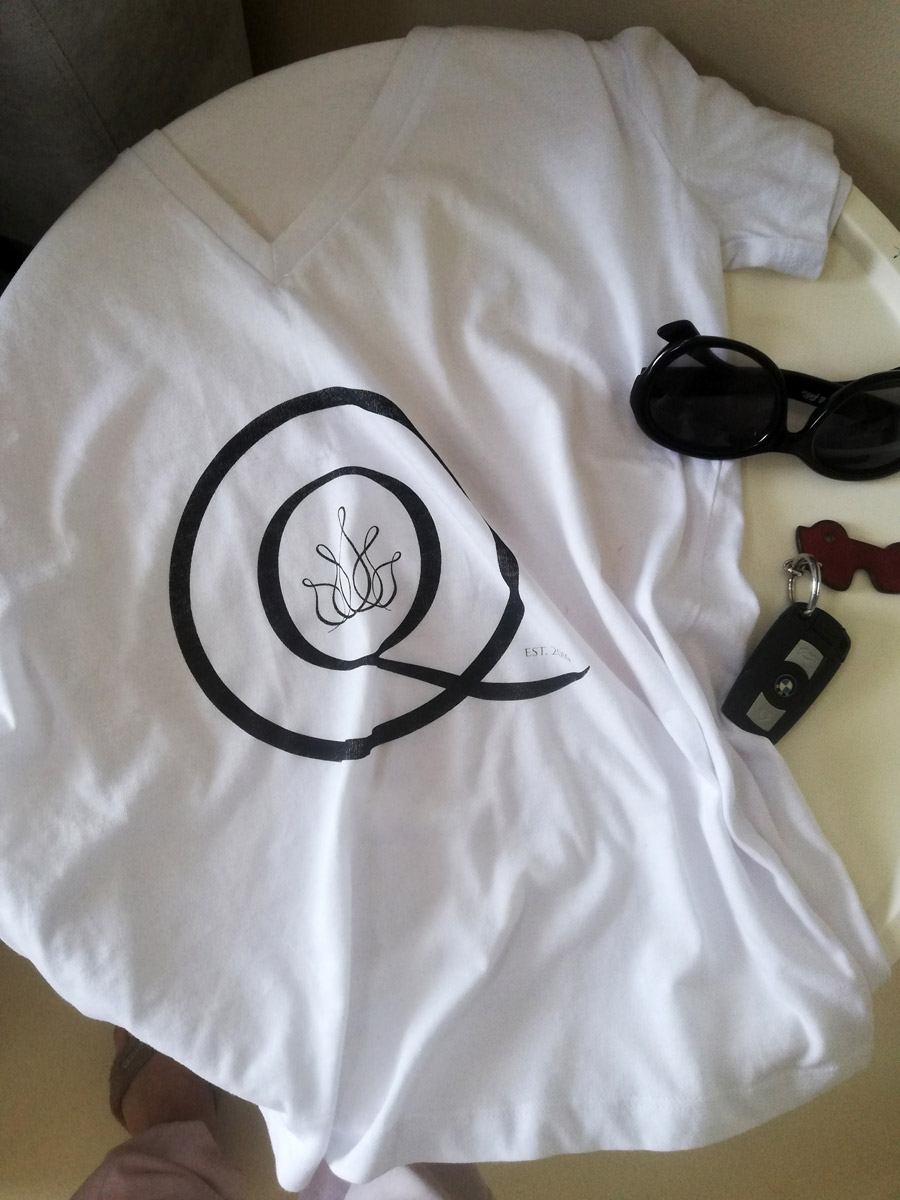 White t-shirt, black sunglasses and car keys on white tabletop